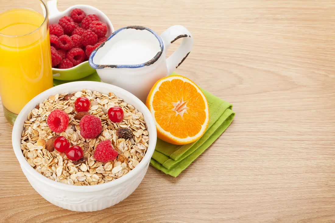 A healthy breakfast including a bowl of oats with berries, orange juice, milk, and fresh fruit on a wooden table, representing brain-friendly nutrition.