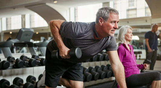 Older adult lifting weights in a gym as part of strength training to support brain health, mobility and cognitive function in neurodegenerative diseases like Parkinson’s and Alzheimer’s